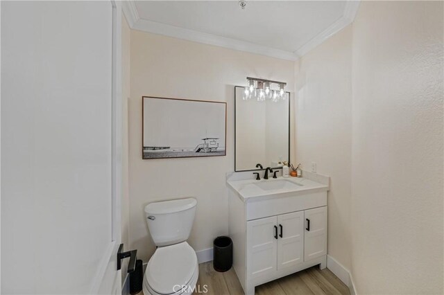 bathroom with crown molding, vanity, toilet, and hardwood / wood-style floors