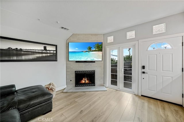 living room with light hardwood / wood-style flooring and a large fireplace