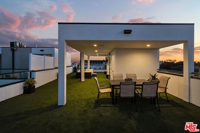 patio terrace at dusk with an outdoor hangout area and a yard