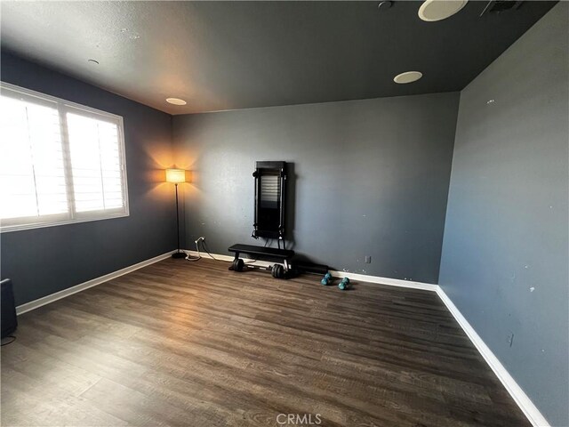 exercise area with dark wood finished floors and baseboards