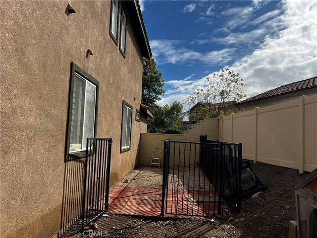 exterior space featuring a fenced backyard and stucco siding