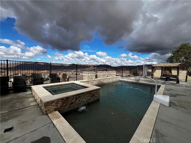 view of pool with a fenced in pool, fence, a gazebo, and an in ground hot tub