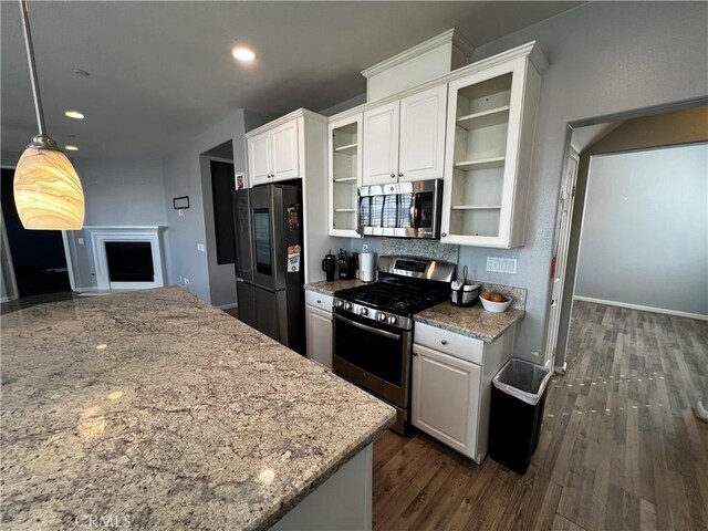 kitchen with stainless steel appliances, glass insert cabinets, and white cabinets