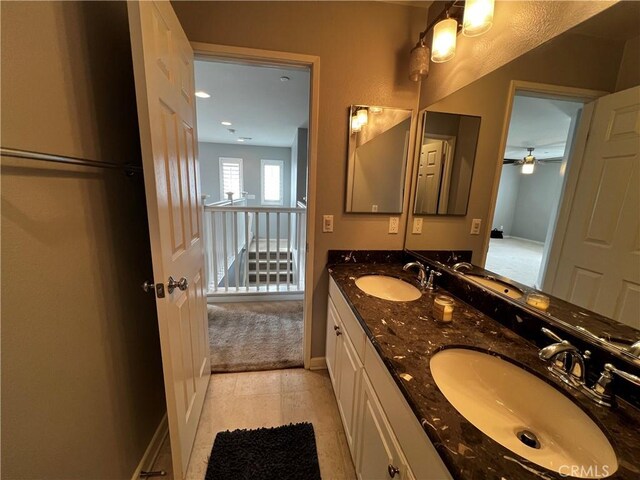 bathroom with double vanity, baseboards, and a sink