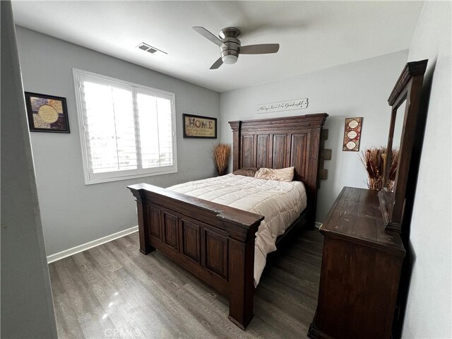 bedroom with dark wood-style floors, visible vents, baseboards, and a ceiling fan