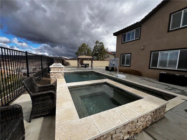 view of pool featuring a patio area, fence, a fenced in pool, and an in ground hot tub