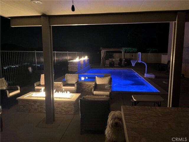 view of pool with a patio area, fence, a fire pit, and area for grilling