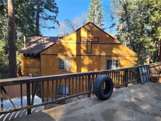 back of house featuring a shingled roof