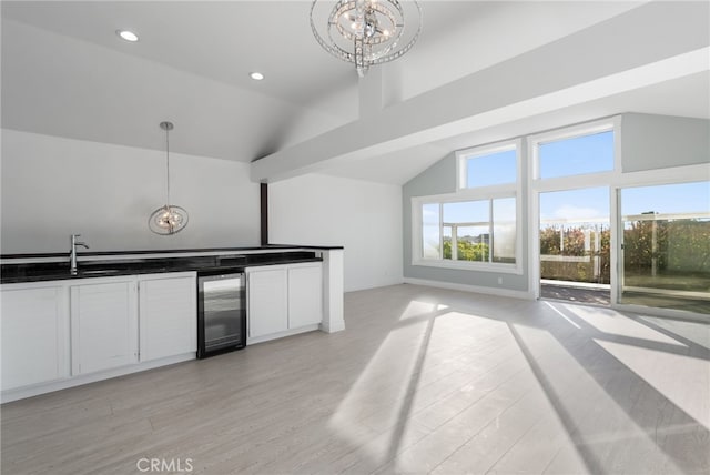 kitchen featuring pendant lighting, sink, white cabinets, wine cooler, and light hardwood / wood-style flooring