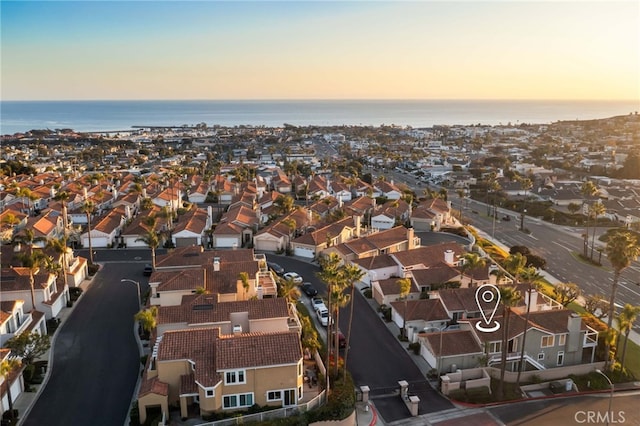 aerial view at dusk featuring a water view