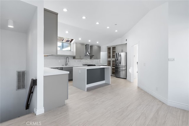 kitchen featuring sink, gray cabinets, a center island, tasteful backsplash, and stainless steel fridge with ice dispenser