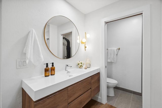 bathroom with vanity, toilet, and tile patterned flooring