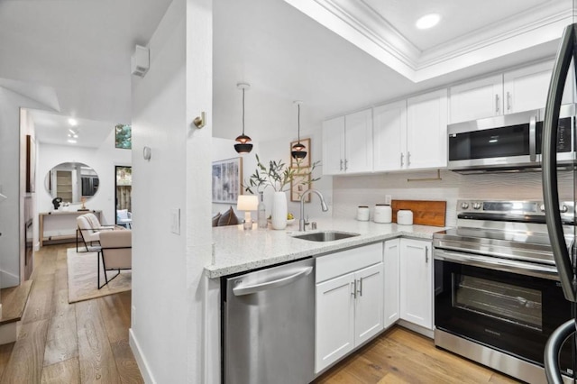 kitchen with sink, ornamental molding, stainless steel appliances, light hardwood / wood-style floors, and white cabinets