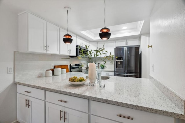 kitchen with white cabinetry, stainless steel appliances, a tray ceiling, and decorative light fixtures