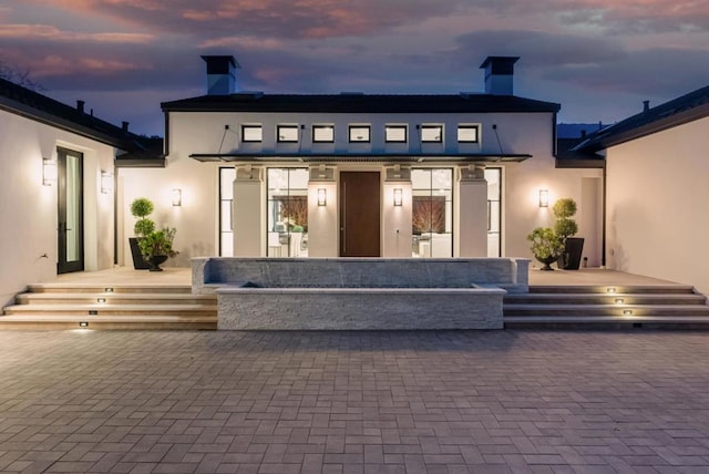 view of back house at dusk