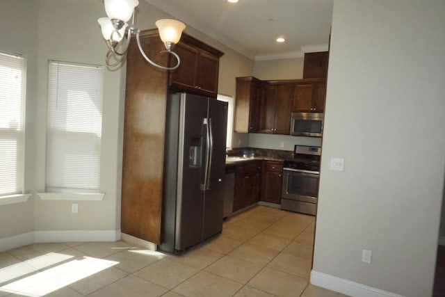 kitchen featuring dark brown cabinetry, light tile patterned floors, appliances with stainless steel finishes, ornamental molding, and a notable chandelier