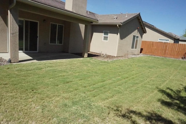 back of property with a patio area and a lawn