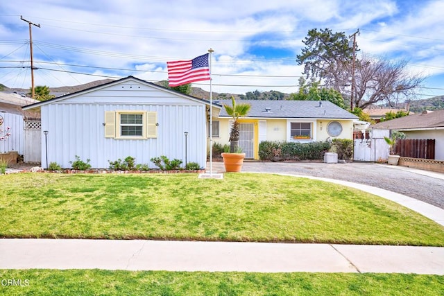 ranch-style home featuring driveway, a front lawn, and fence