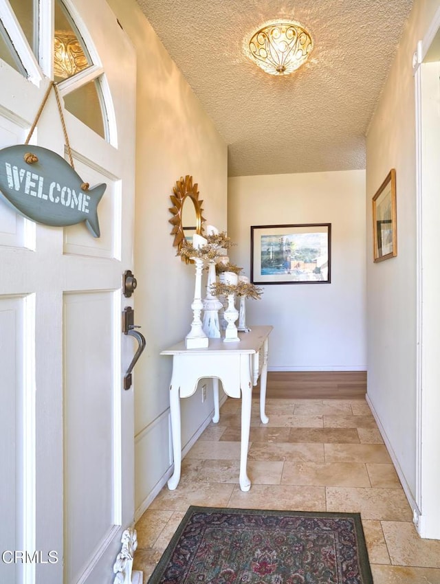 interior space featuring baseboards and a textured ceiling