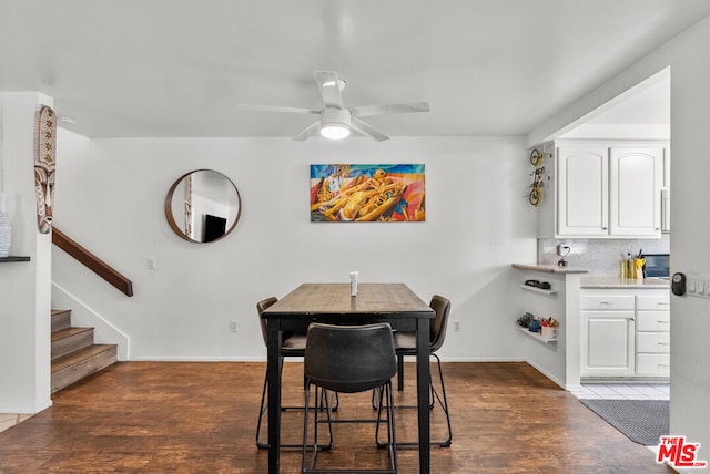 dining space with dark wood-type flooring and ceiling fan