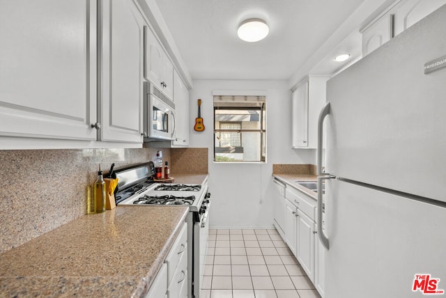 kitchen featuring white cabinetry, light tile patterned floors, white appliances, light stone countertops, and decorative backsplash