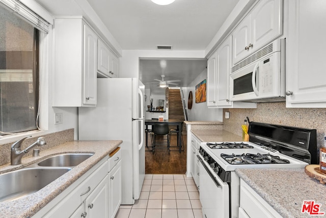 kitchen with light tile patterned flooring, sink, white cabinets, ceiling fan, and white appliances