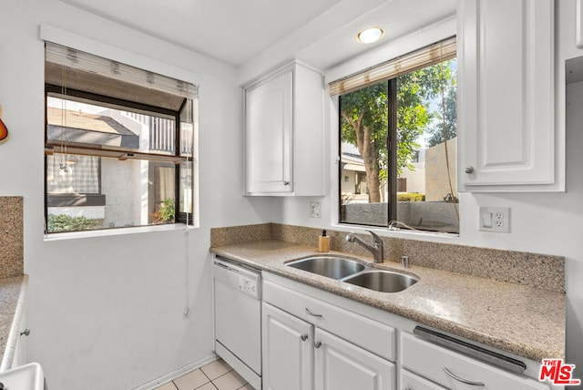 kitchen with light tile patterned floors, white dishwasher, sink, and white cabinets