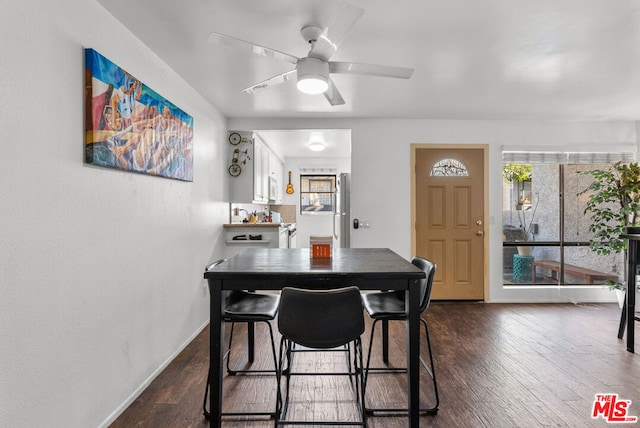 dining space with ceiling fan and dark hardwood / wood-style flooring