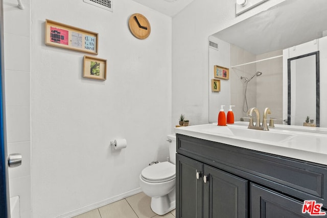 bathroom featuring vanity, tile patterned floors, and toilet