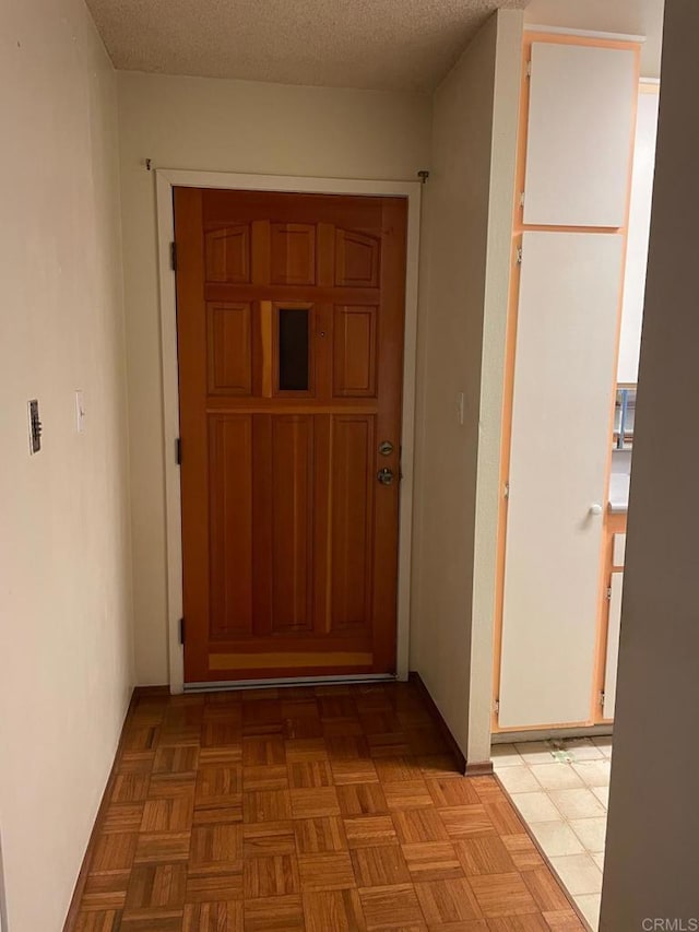 hall with a textured ceiling and light parquet flooring