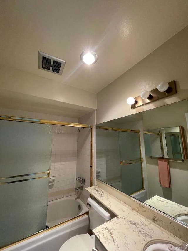 full bathroom with toilet, vanity, and bath / shower combo with glass door