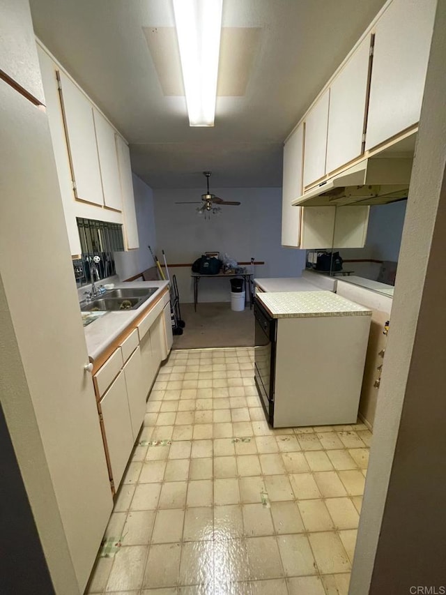 kitchen featuring ceiling fan, sink, and white cabinets