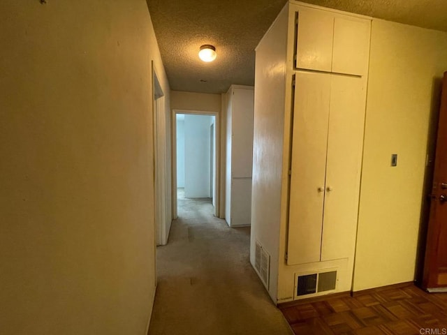 corridor with dark parquet floors and a textured ceiling