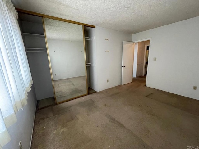 unfurnished bedroom featuring carpet floors, a closet, and a textured ceiling