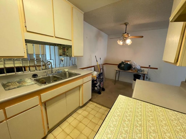 kitchen featuring ceiling fan, sink, a textured ceiling, and cream cabinetry