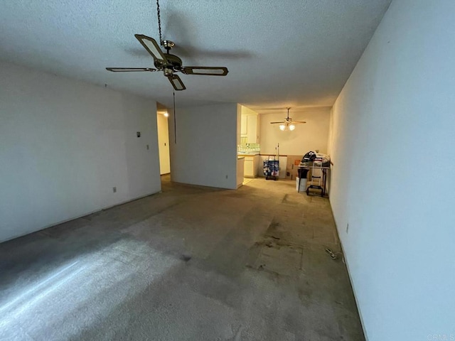 unfurnished living room featuring ceiling fan and a textured ceiling