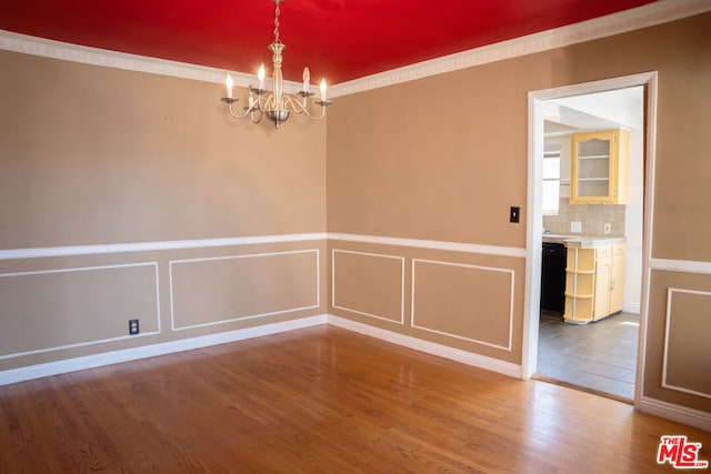 unfurnished room featuring hardwood / wood-style floors and a chandelier