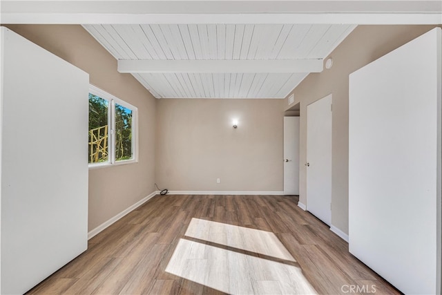 unfurnished room featuring beam ceiling and hardwood / wood-style flooring