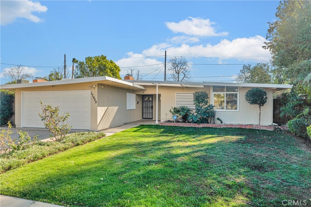 single story home featuring a garage and a front yard