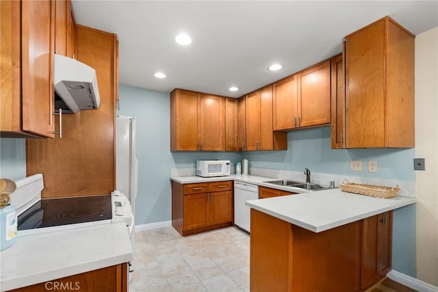 kitchen featuring sink, white appliances, and kitchen peninsula