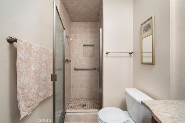 bathroom featuring vanity, toilet, and an enclosed shower