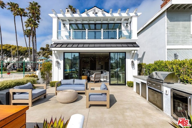 view of patio / terrace with a balcony, a grill, area for grilling, wine cooler, and an outdoor living space