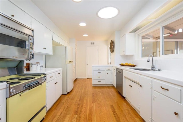 kitchen with sink, stainless steel appliances, white cabinets, and light wood-type flooring