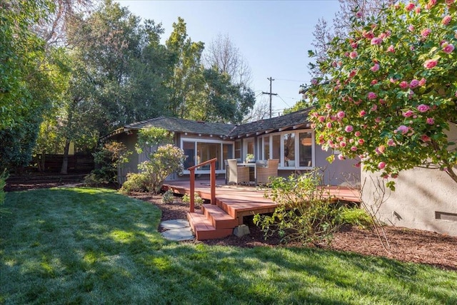 back of house featuring a wooden deck and a yard