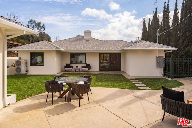 rear view of house with a patio area and a lawn