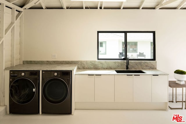 laundry room featuring sink, washer and clothes dryer, and cabinets