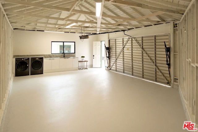 garage with sink, a garage door opener, and washer and dryer