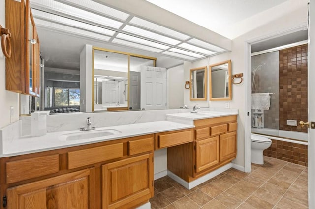 full bathroom featuring toilet, vanity, and shower / bath combination with glass door