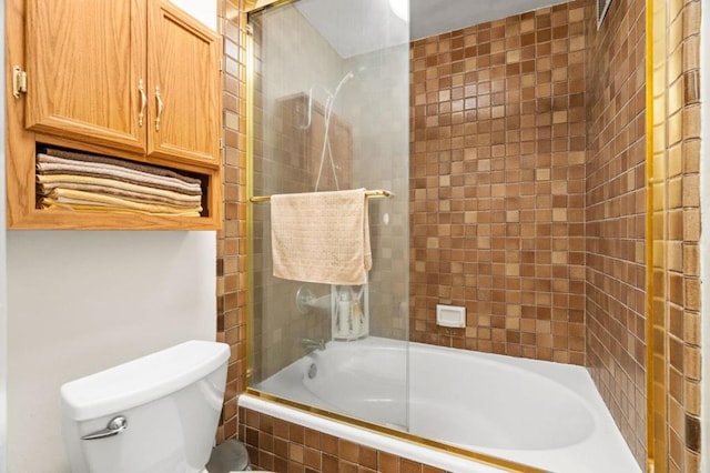 bathroom with toilet and combined bath / shower with glass door