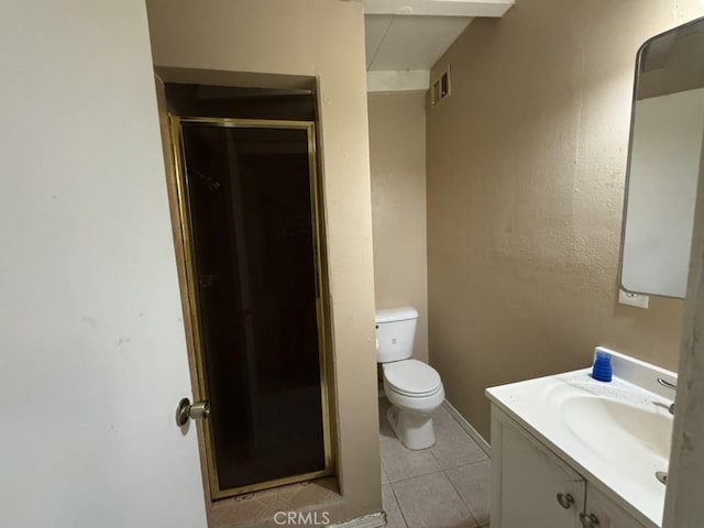 bathroom with vanity, tile patterned floors, a shower with door, and toilet